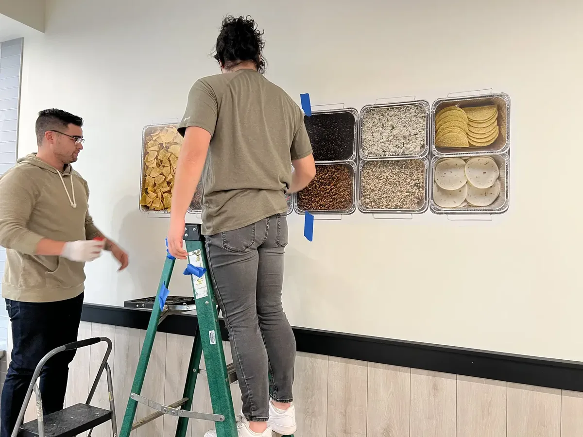 Smiles and Signs crew installing wall graphics on a restaurant dining room wall in Shelbyville, TN