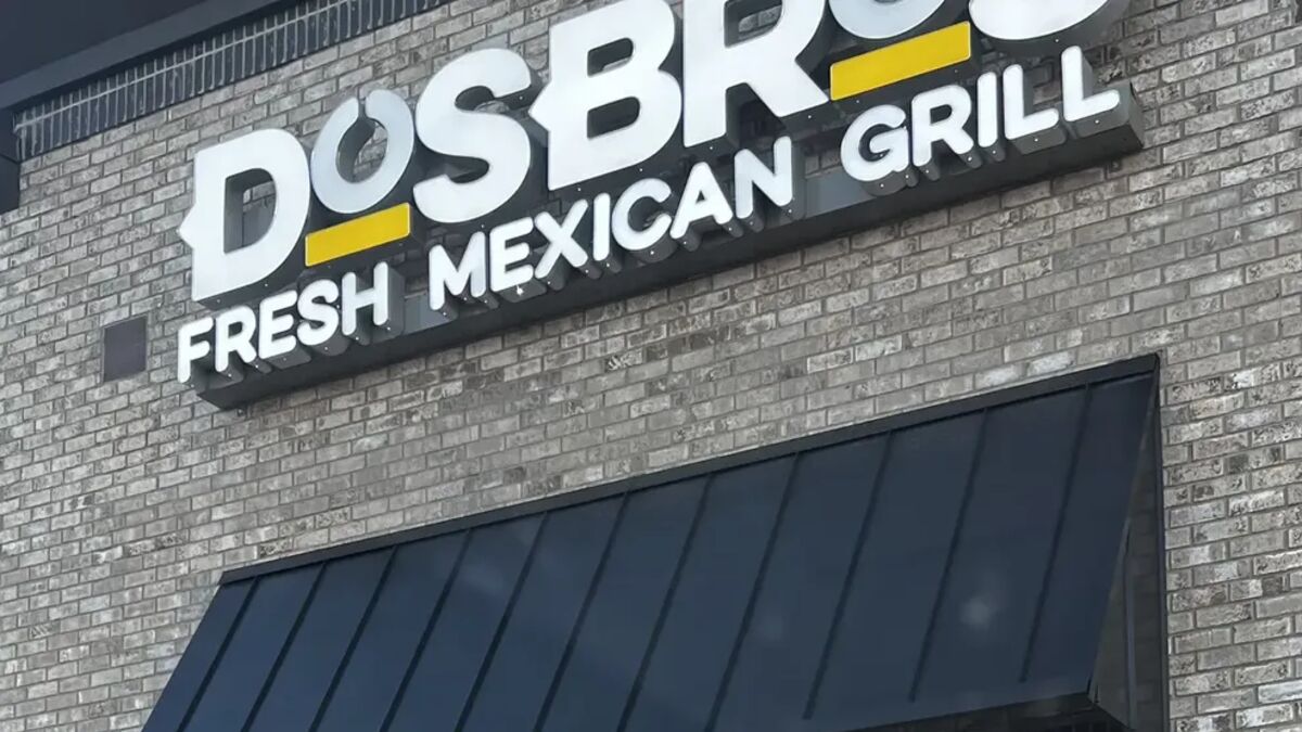 Restaurant storefront with an illuminated sign, awning and window graphics