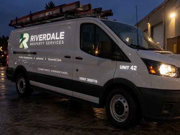 Service van at night with reflective company lettering, unit number and USDOT number lit by headlights