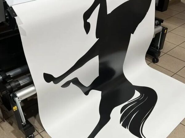 Large black-and-white print coming off a wide-format printer