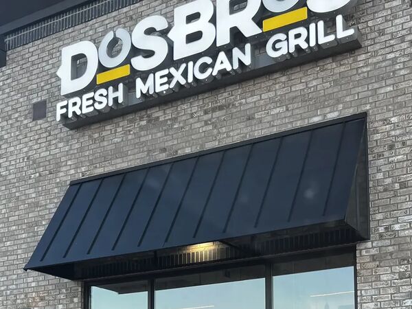 Restaurant storefront with an illuminated sign and window graphics